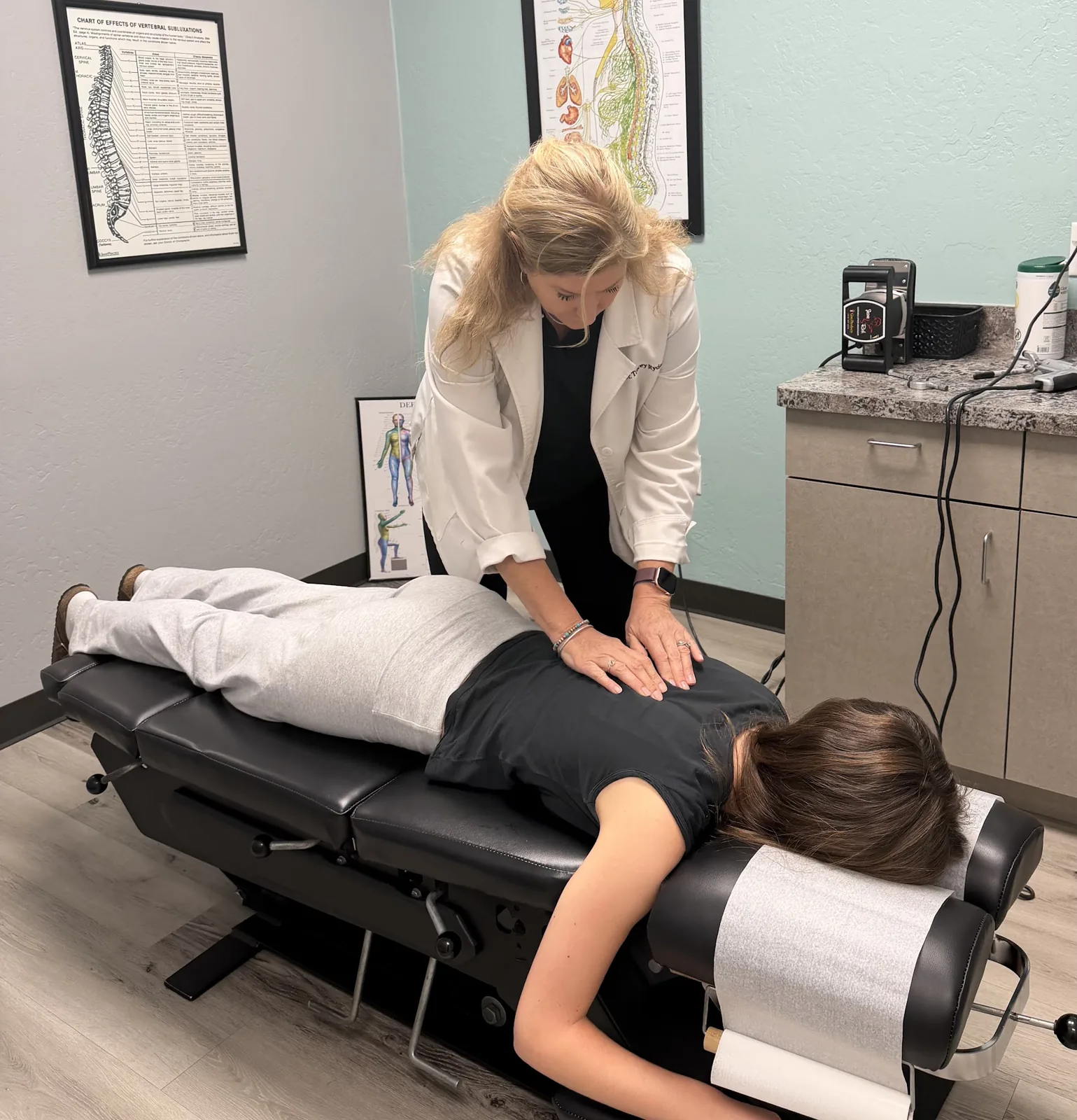 Dr. Tracey Ryder adjusting a patient's mid back on the table in a treatment room at Ryder Chiropractic in Scottsdale